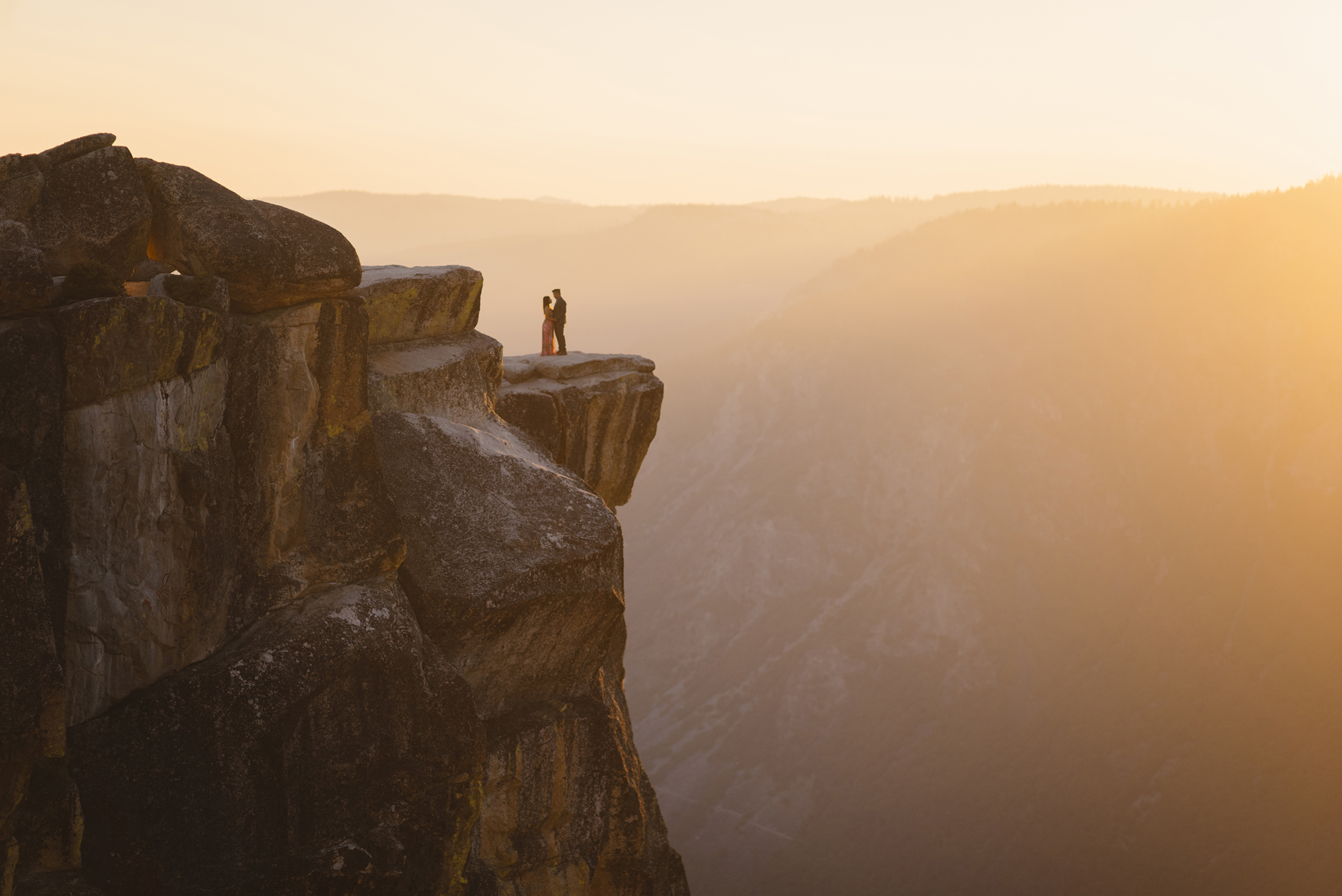 Romantic couple on cliff of taft point at sunset by Yosemite Elopement Photographer Colby and Jess colbyandjess.com