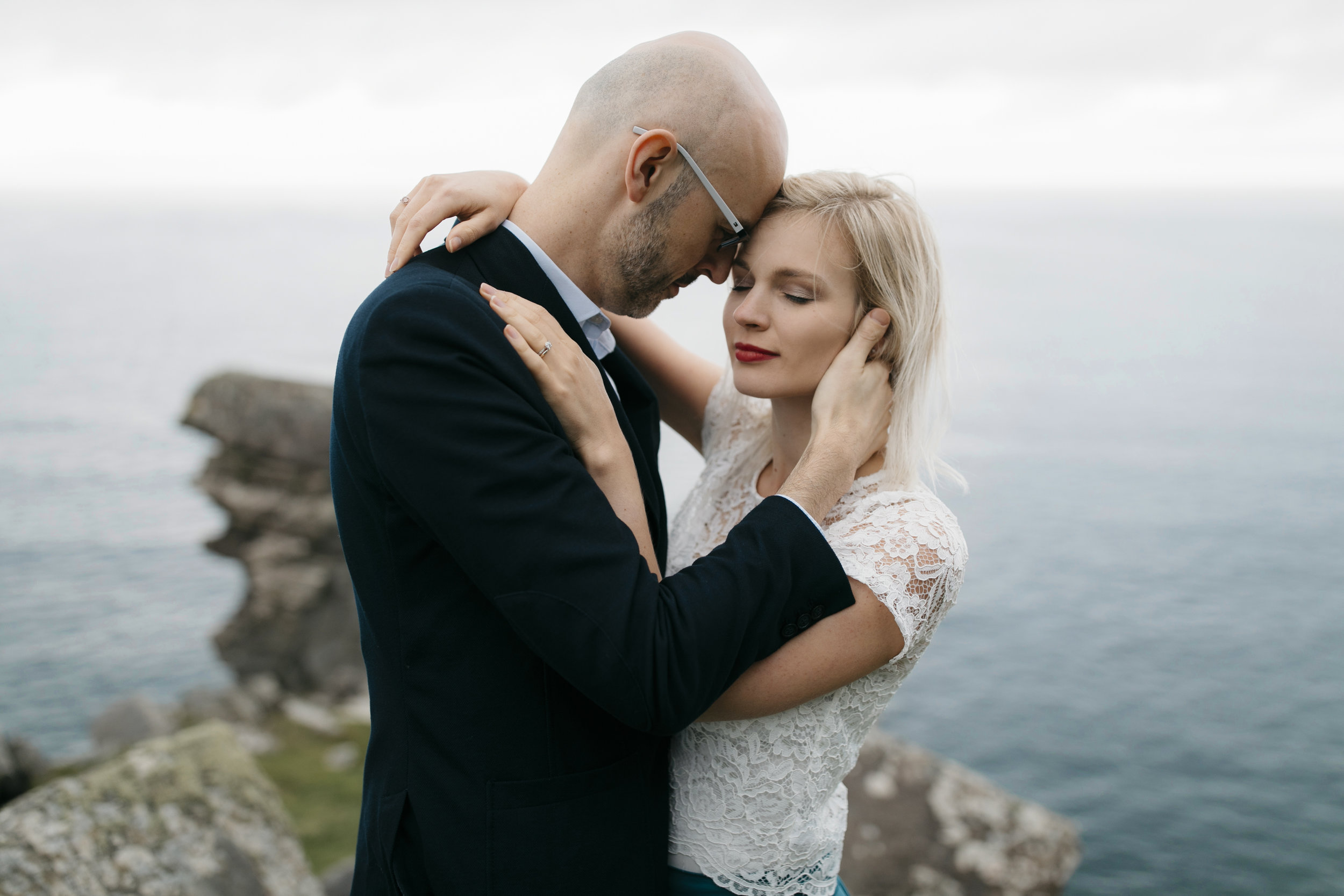 A man taking his wife closely in his arms during Cliffs of Moher Adventure Photography Session by Ireland Elopement Photographer Colby and Jess