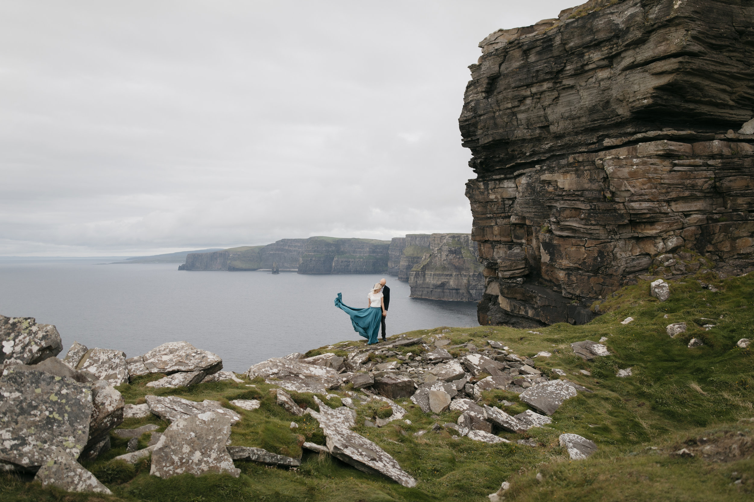 A lovely couple embrace each other during epic photography session at Cliffs of Moher by Ireland Elopement Photographers Colby and Jess