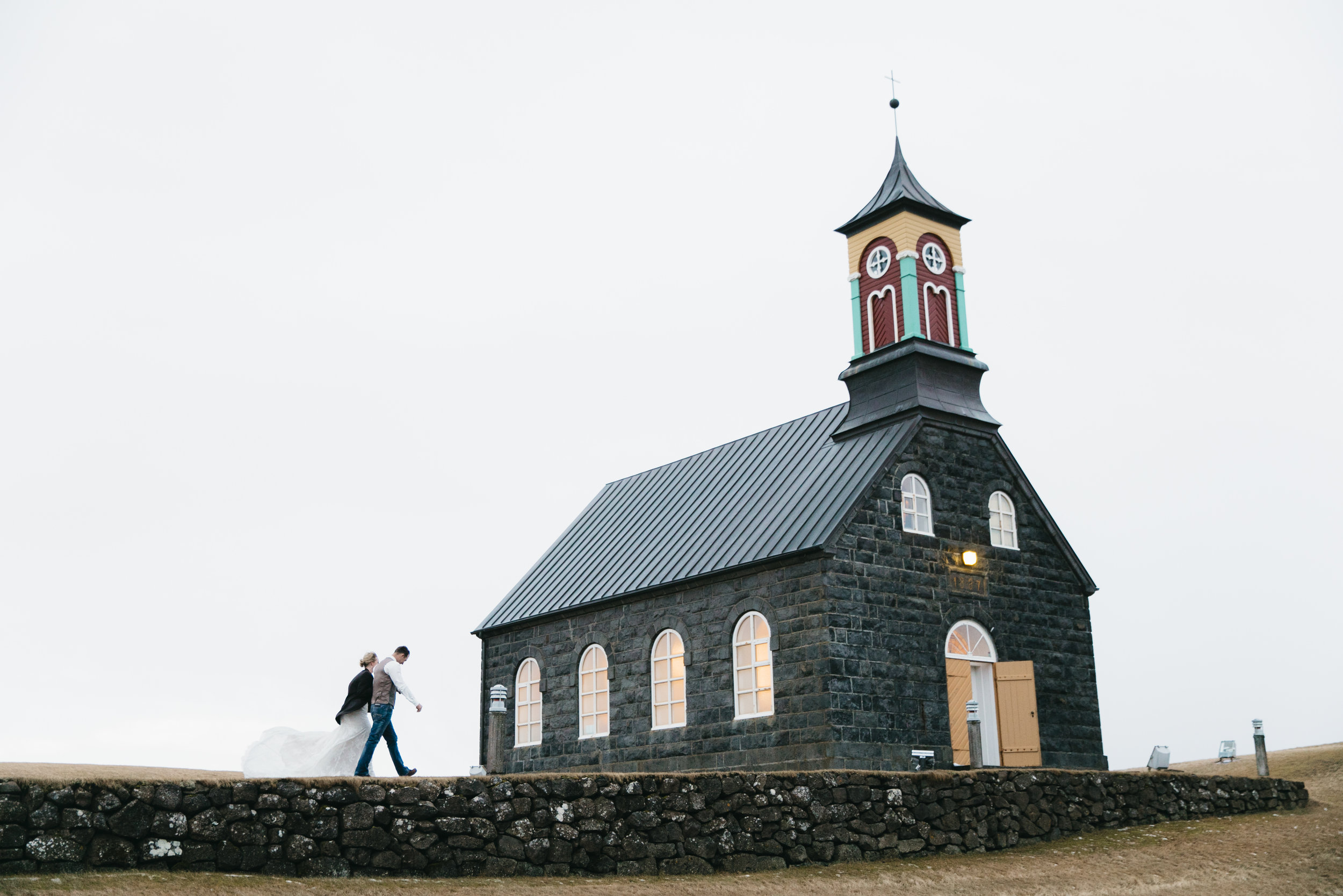 Couple walks to Church at Hvalsnes for elopement ceremony, photo by Iceland Wedding Photographers Colby and Jess.