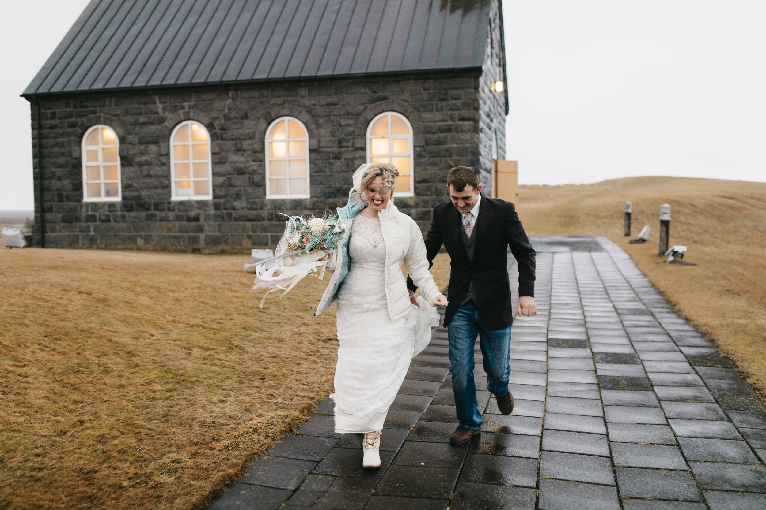 The happy married couple leaves the Hvalsneskirkja Church after finishing elopement ceremony with their Iceland Elopement photographers Colby and Jess, colbyandjess.com