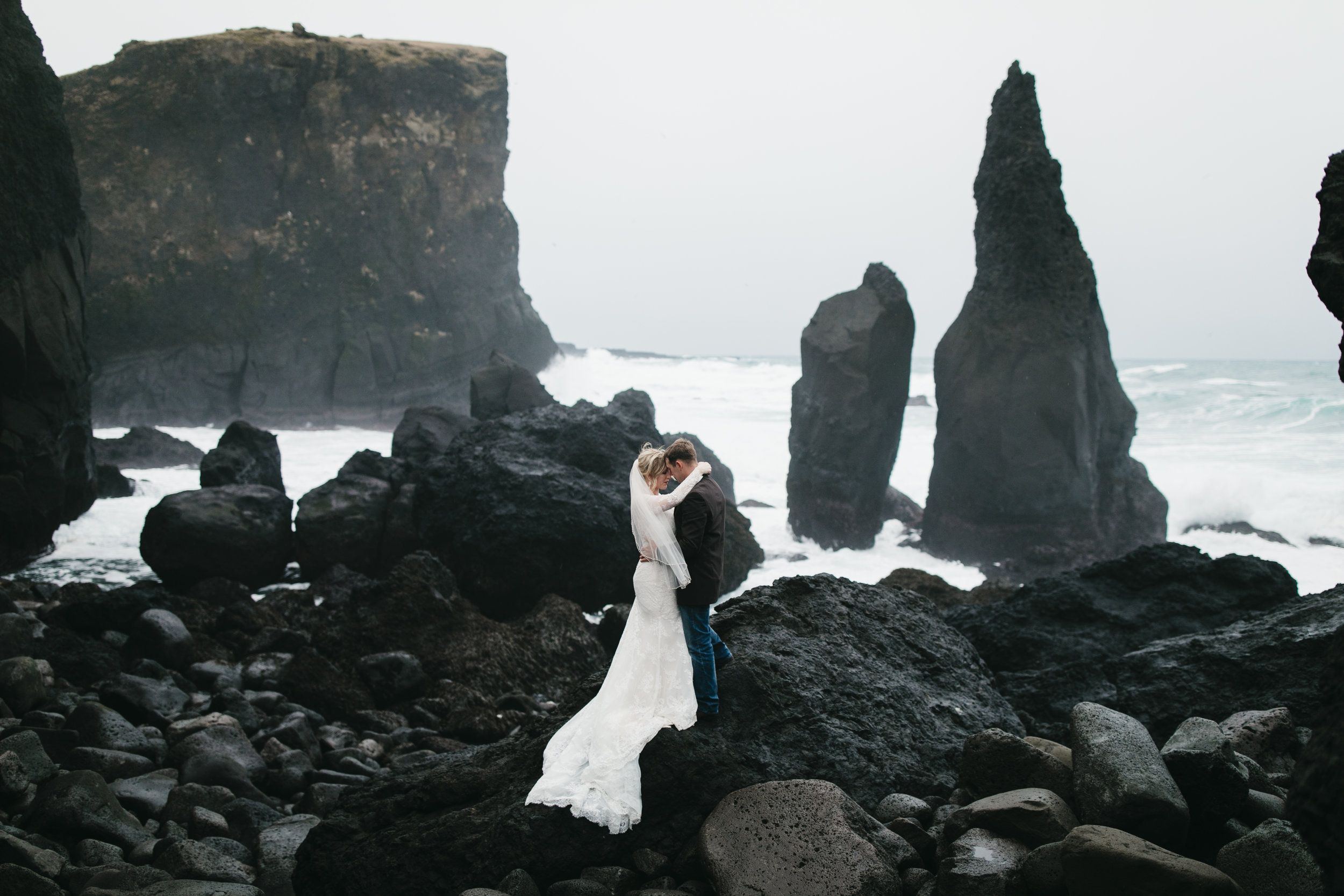 A couple snuggles at Reykjanes peninsula after their adventure elopement in Iceland by destination wedding photographers colby and jess, colbyandjess.com