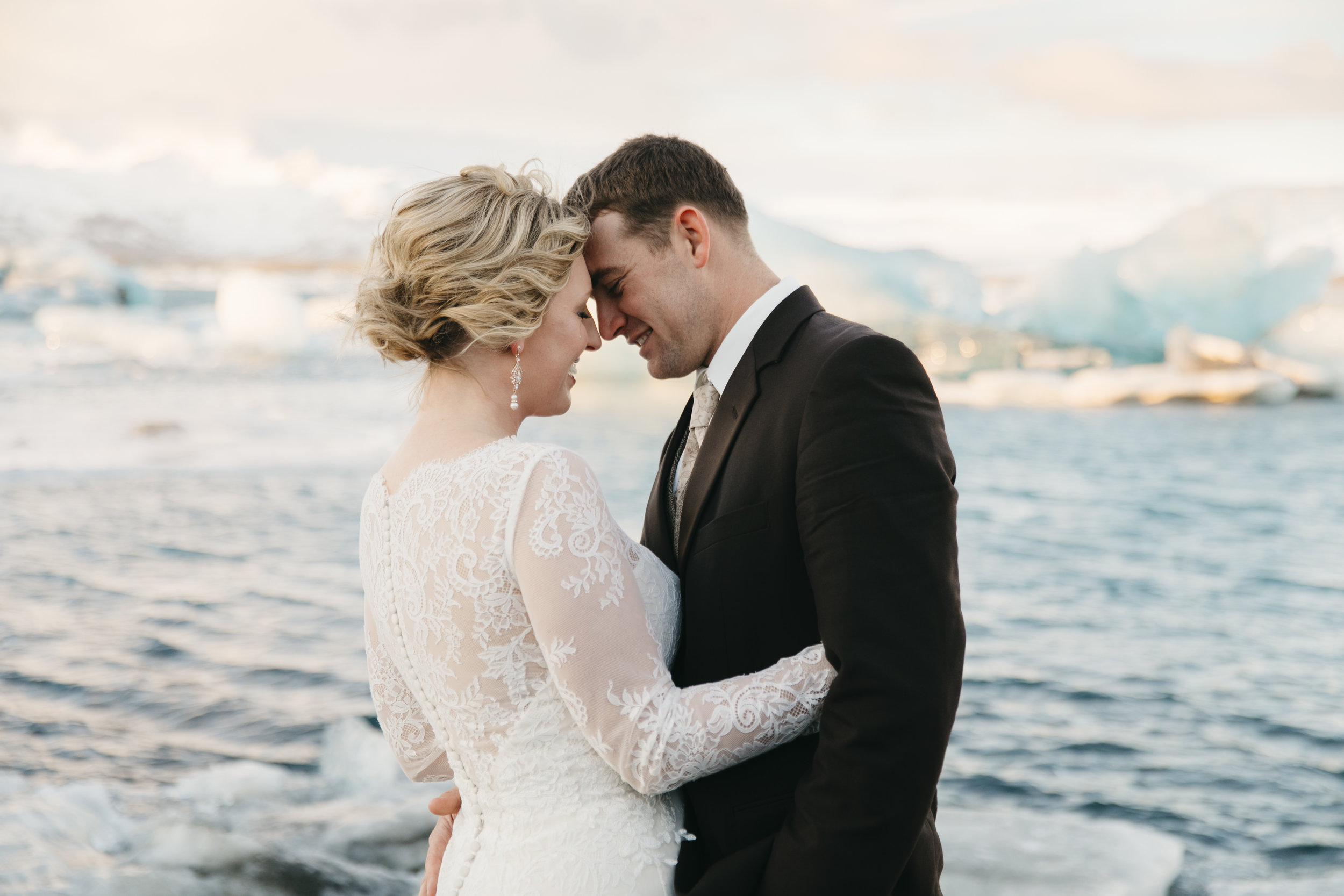 A couple stands next to a glacier during their jokulsarlon elopement with Iceland wedding photographers Colby and Jess.