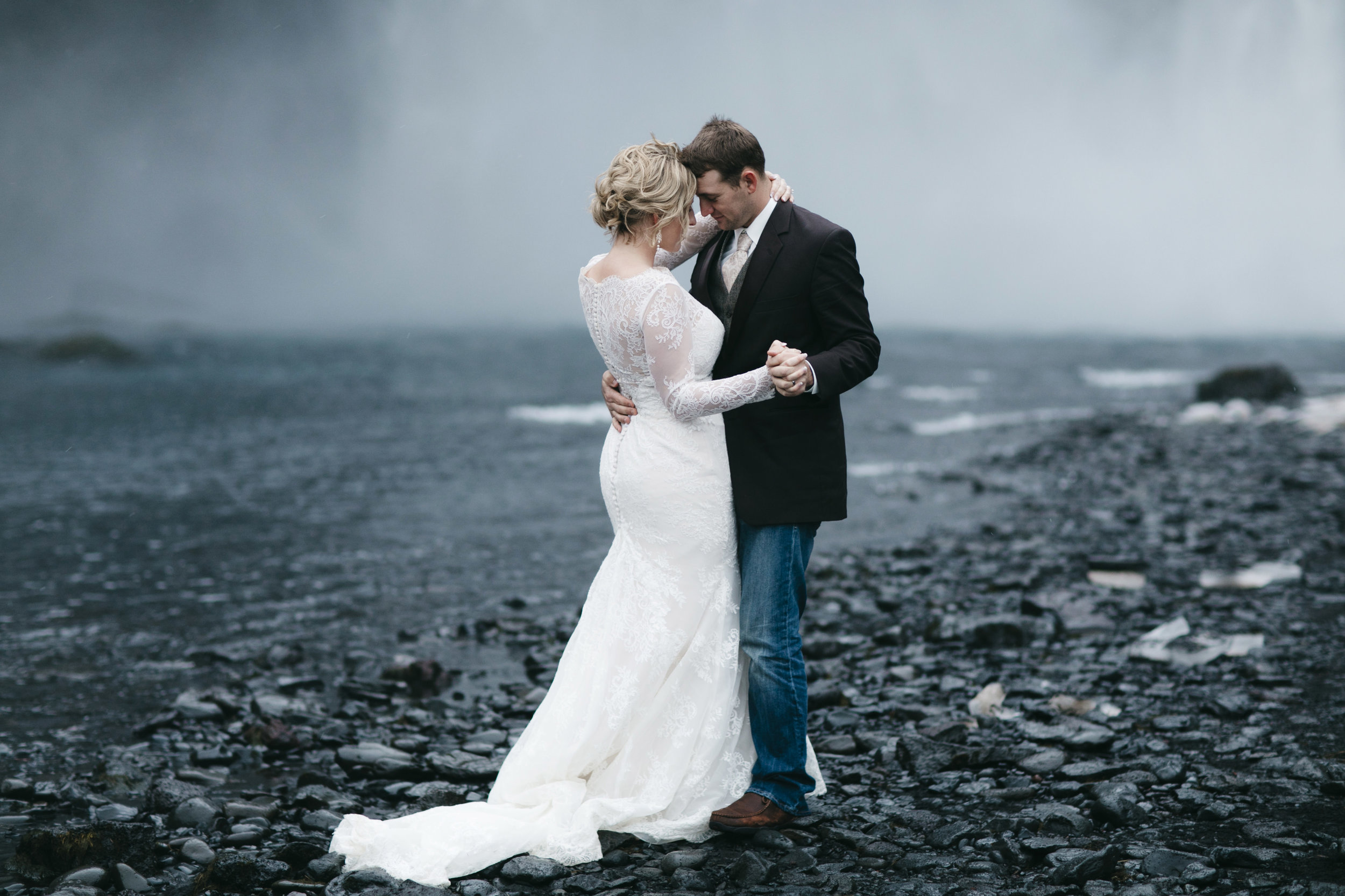 Following their elopement at Skogafoss, a couple shares their first dance by a waterfall with Iceland Elopement photographers Colby and Jess, colbyandjess.com