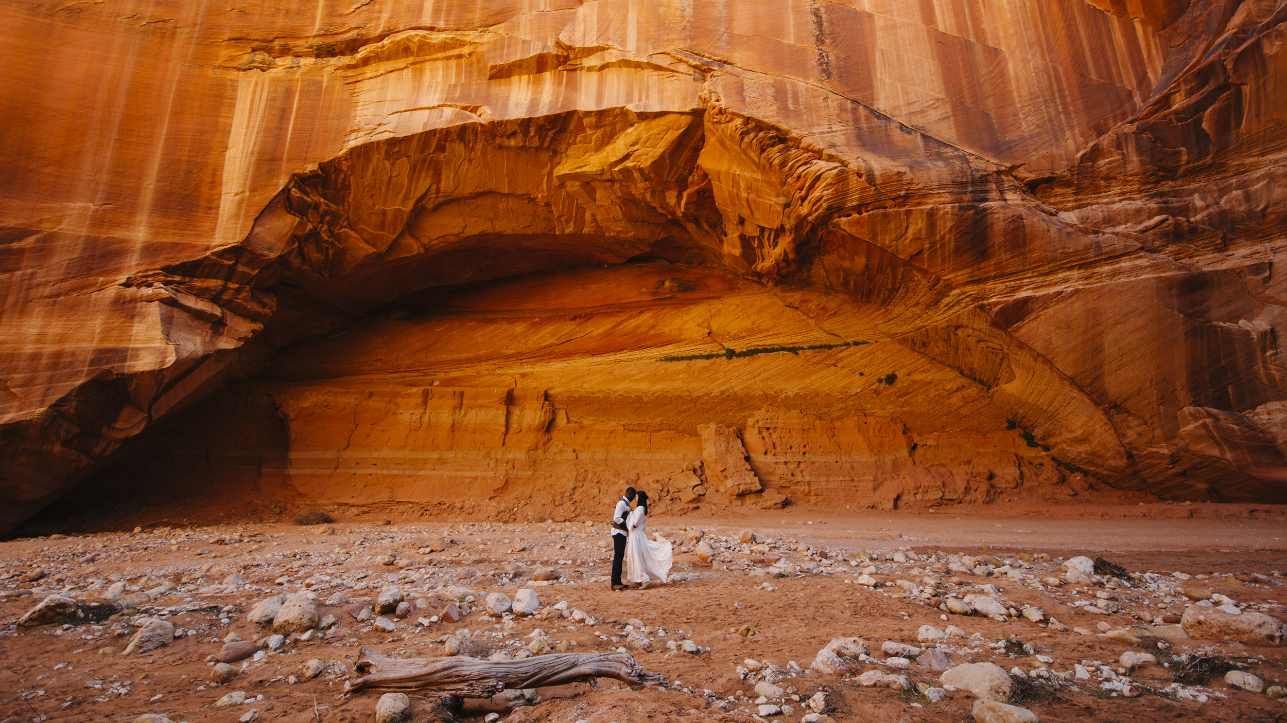 A couple stands under an archway at Antelope Canyon with Utah Destination Elopement Photographer Colby and Jess