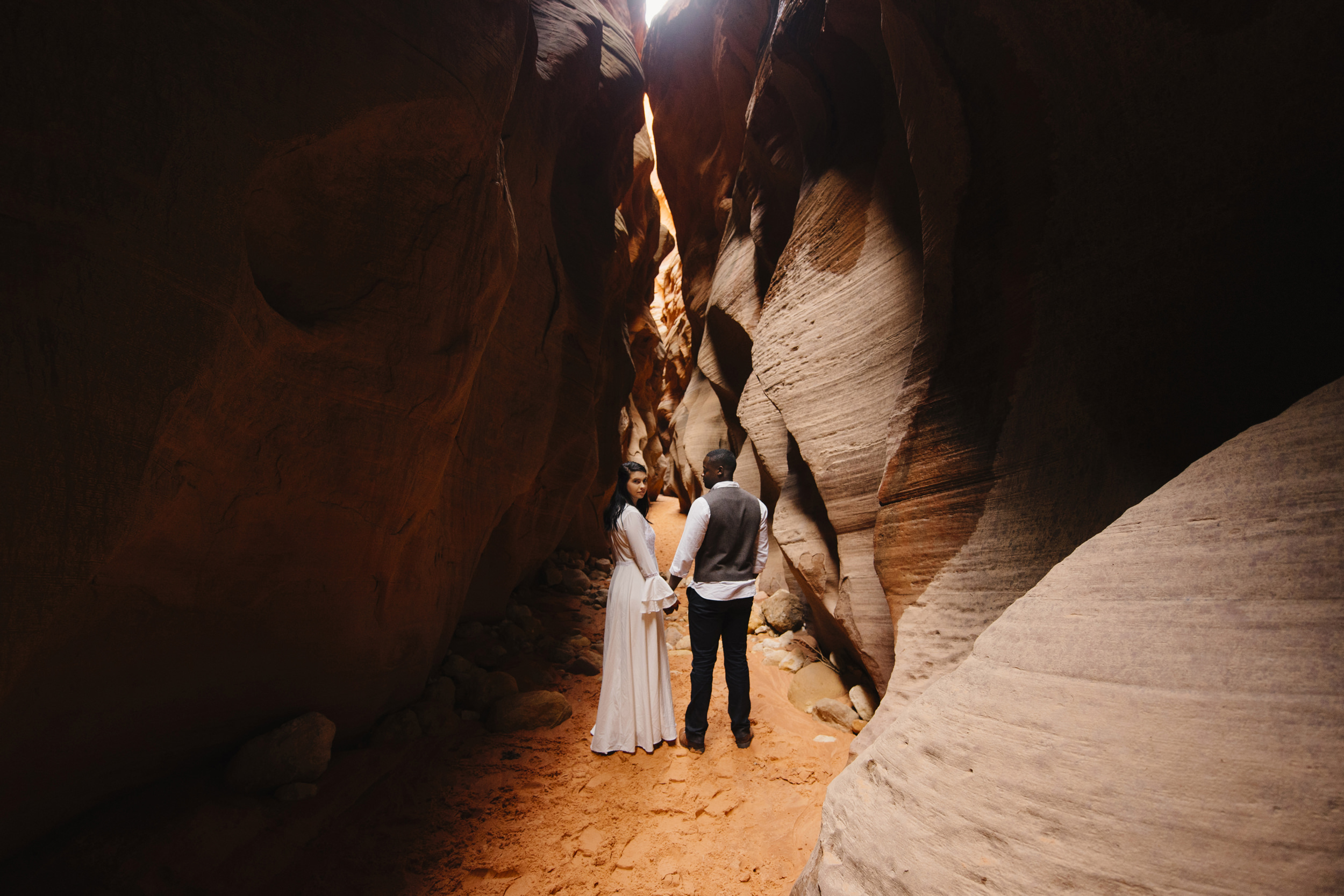 A couple explores Antelope Canyon during their adventure photography session by Utah Destination Elopement Photographer Colby and Jess