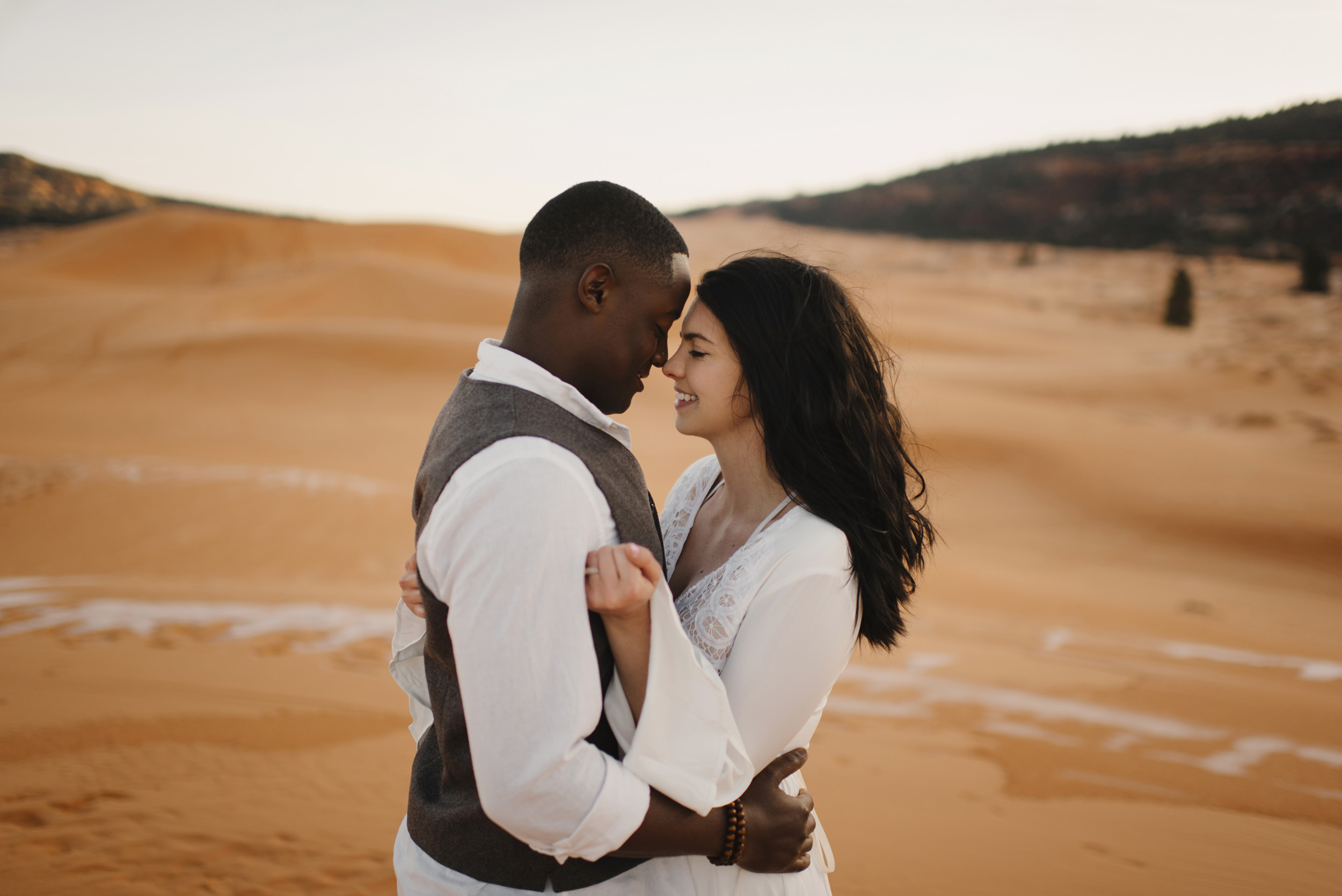 A couple snuggles during their adventure anniversary photography session with Utah Sand Dunes Destination Elopement Photographer Colby and Jess