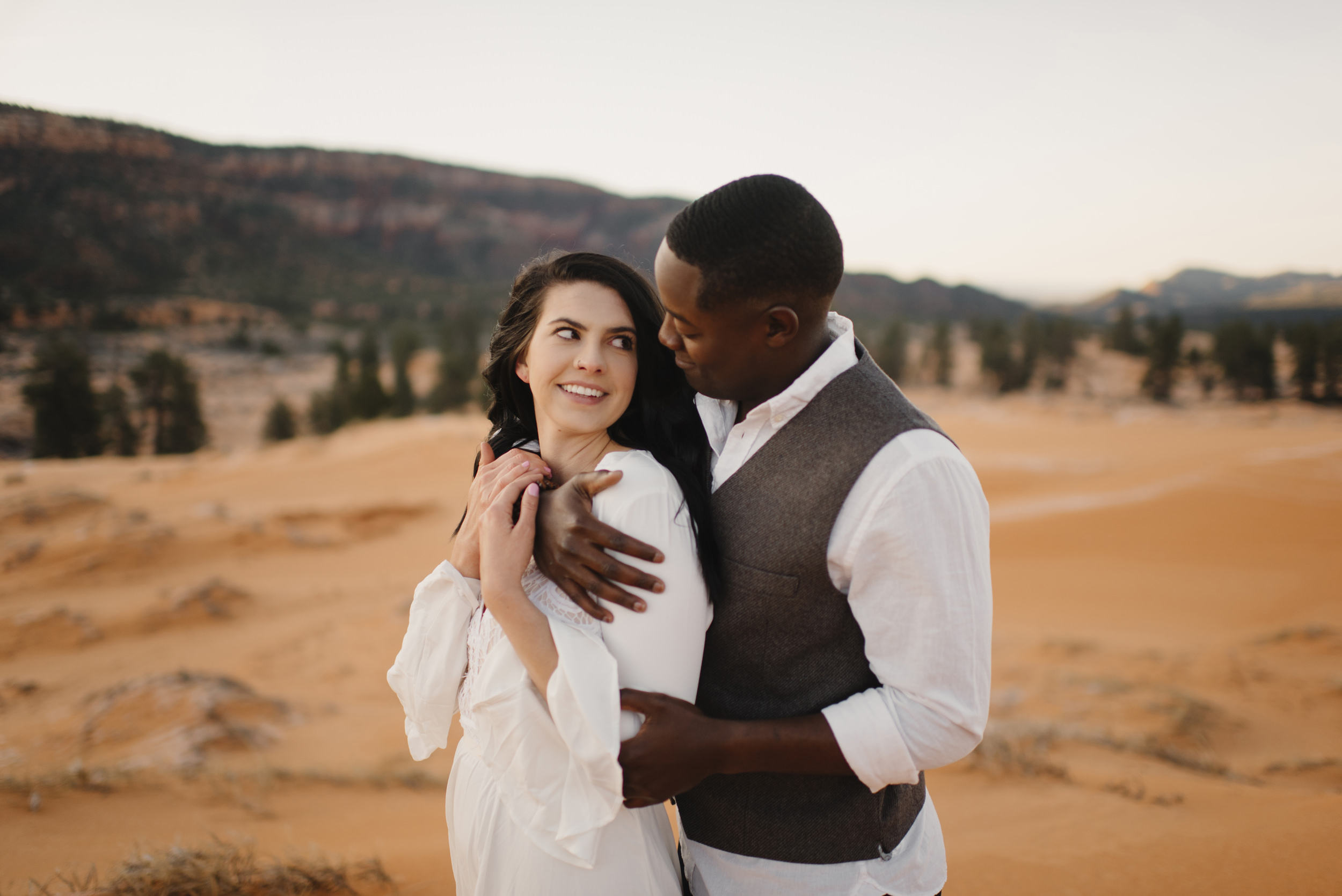 A couple snuggles during their adventure anniversary photography session with Utah Sand Dunes Destination Elopement Photographer Colby and Jess