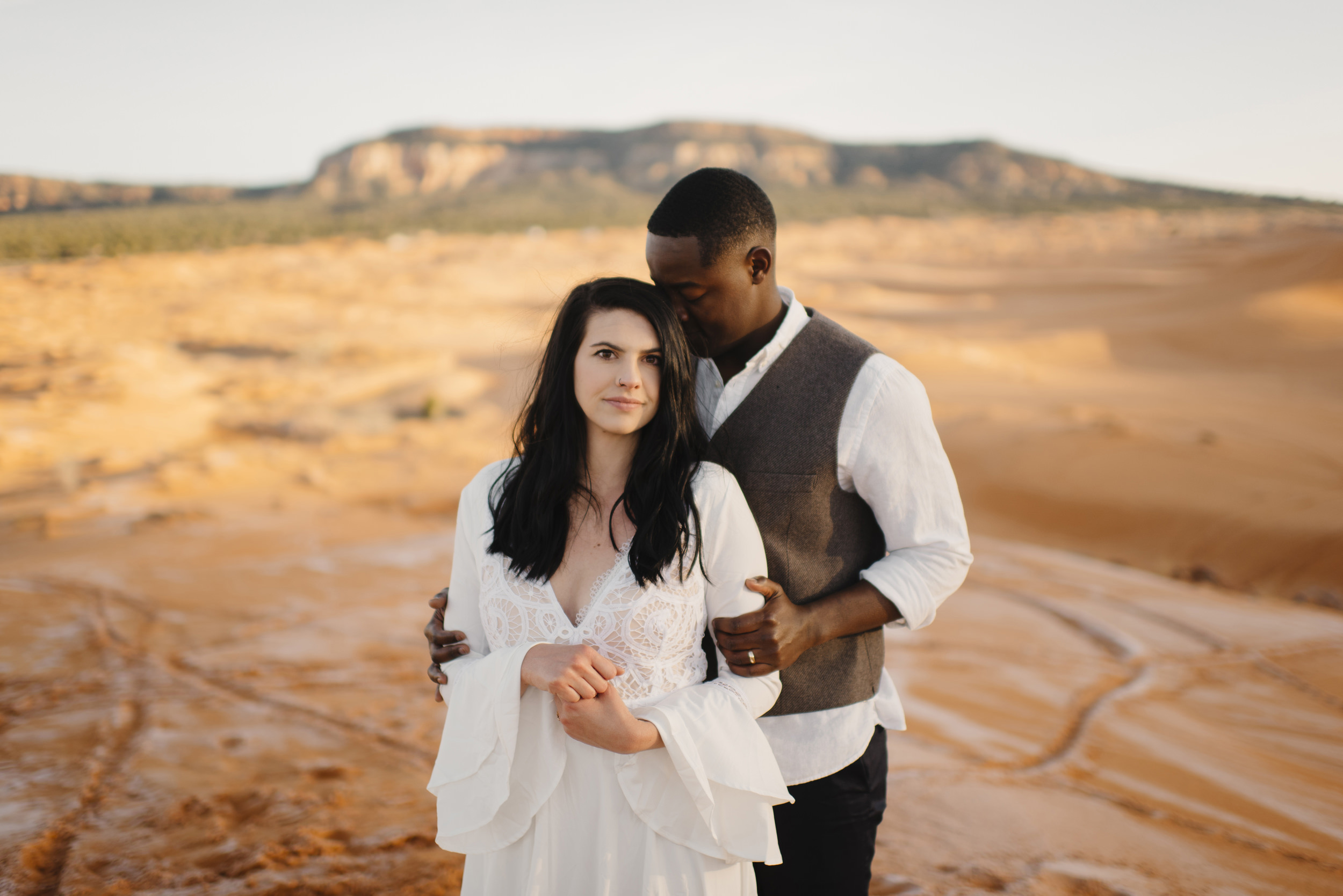 A couple snuggles during their adventure anniversary photography session with Utah Sand Dunes Destination Elopement Photographer Colby and Jess