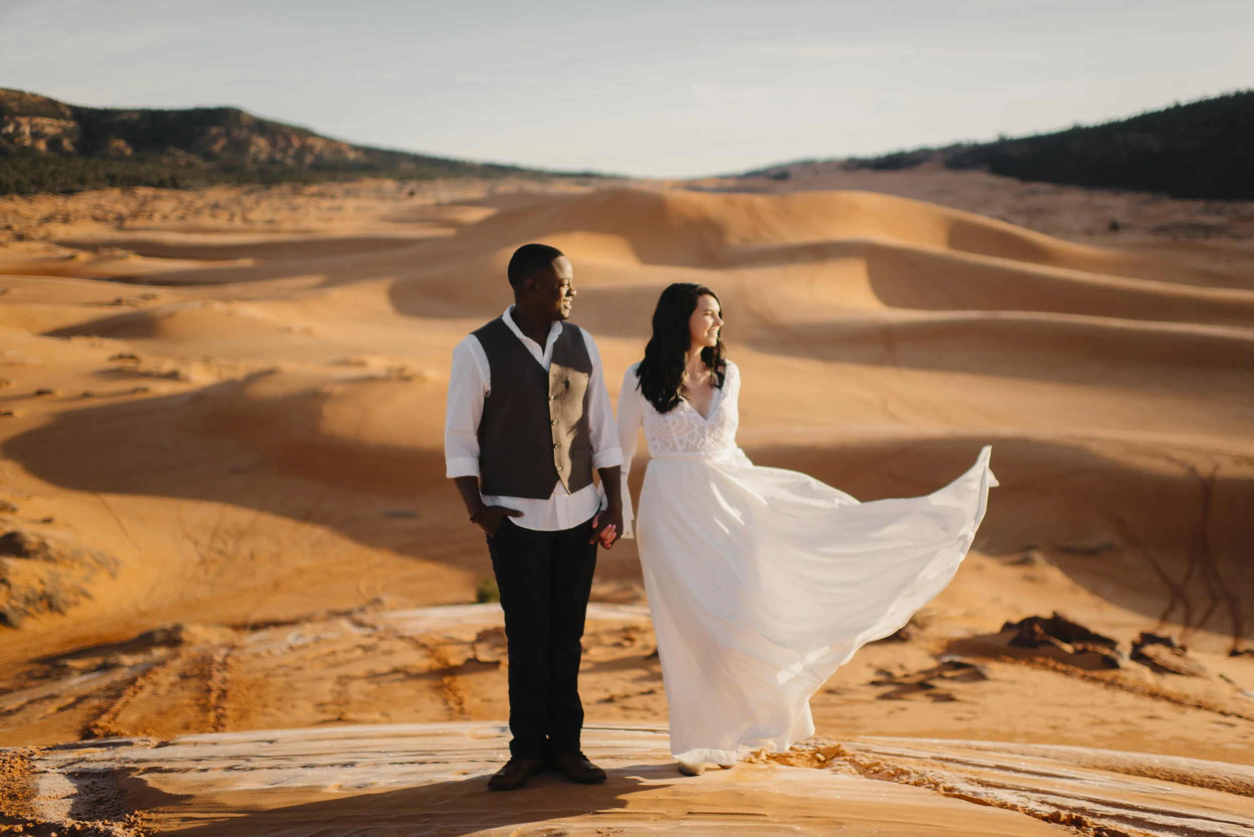 A couple snuggles during their adventure anniversary photography session with Utah Sand Dunes Destination Elopement Photographer Colby and Jess