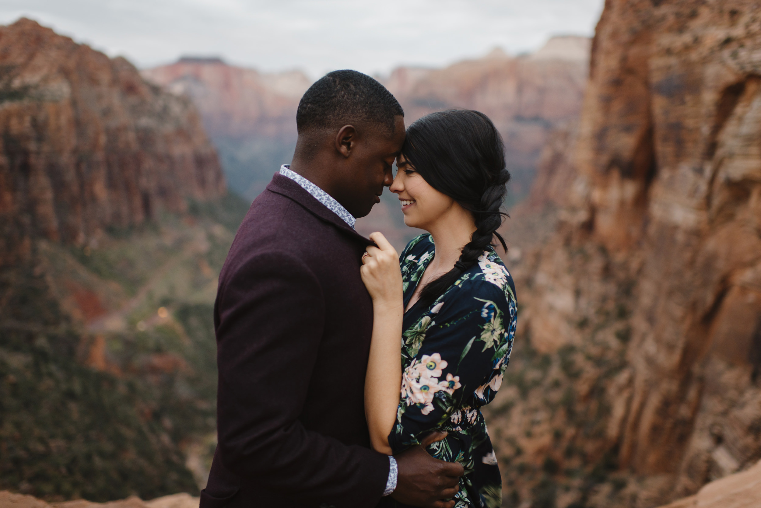 A man and woman snuggle close during their Angels Landing Adventure Engagement Photography Session with Zion National Park Elopement Photographer Colby and Jess