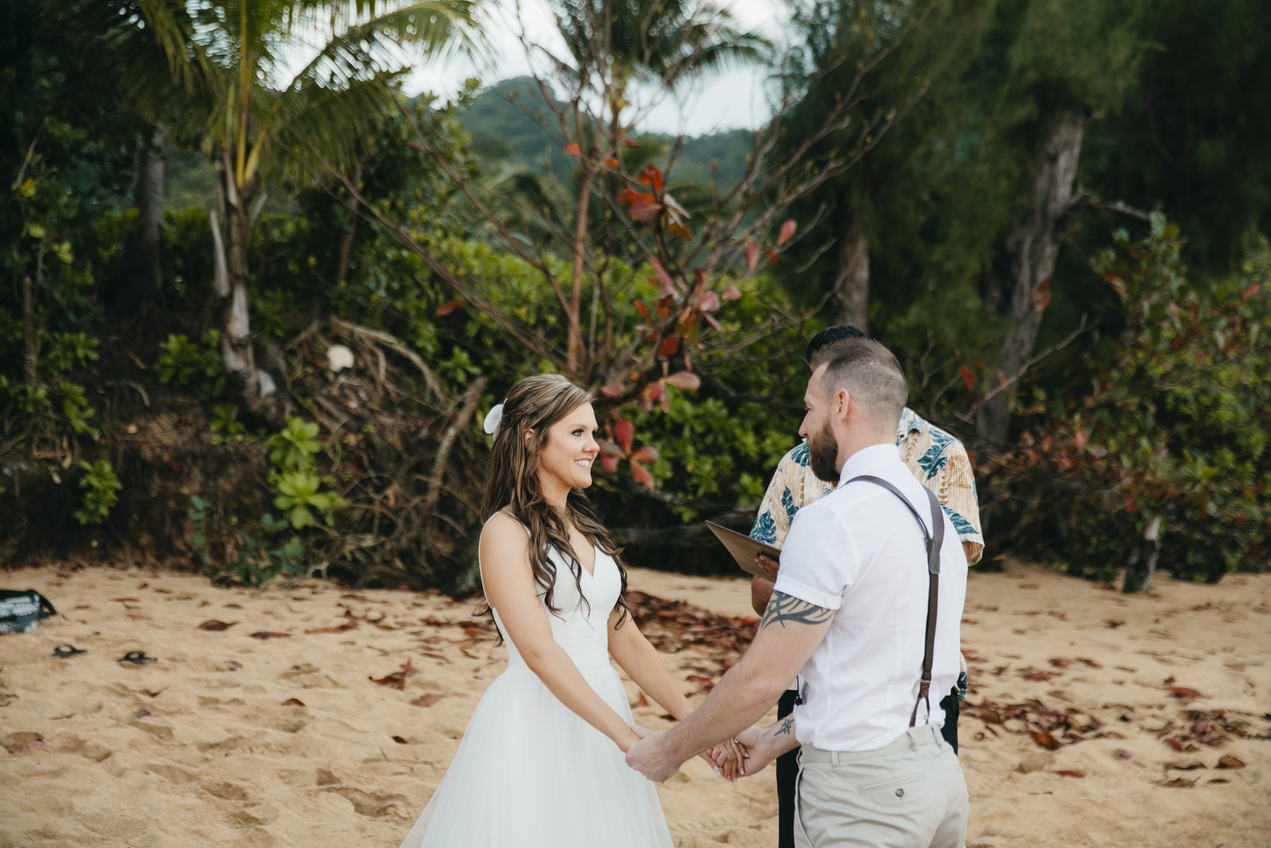 Vows are exchanged during Tunnels Beach wedding ceremony with Kauai Elopement photographers Colby and Jess