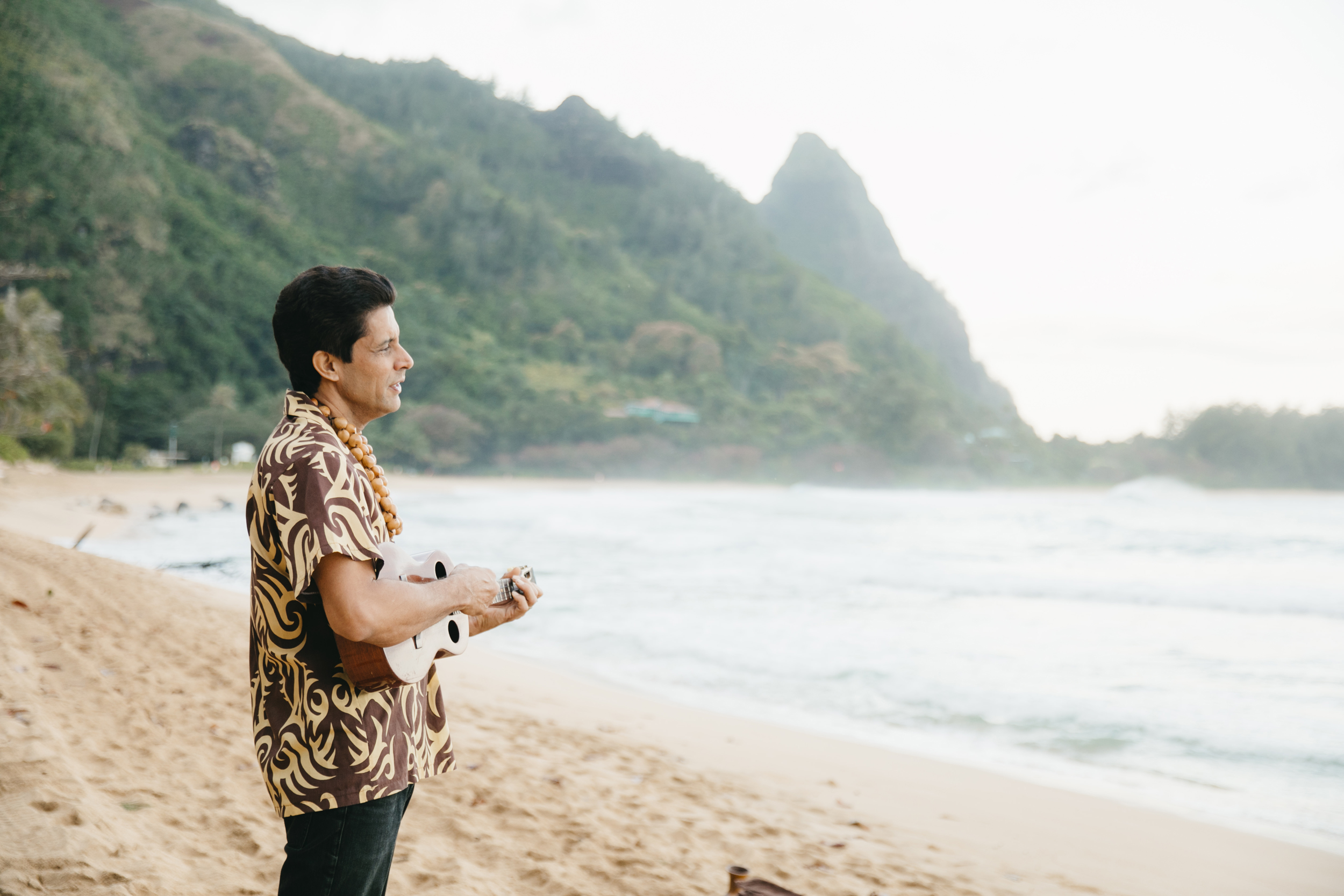 Ukulele player during Tunnels Beach Wedding Ceremony with Kauai Elopement Photographers Colby and Jess