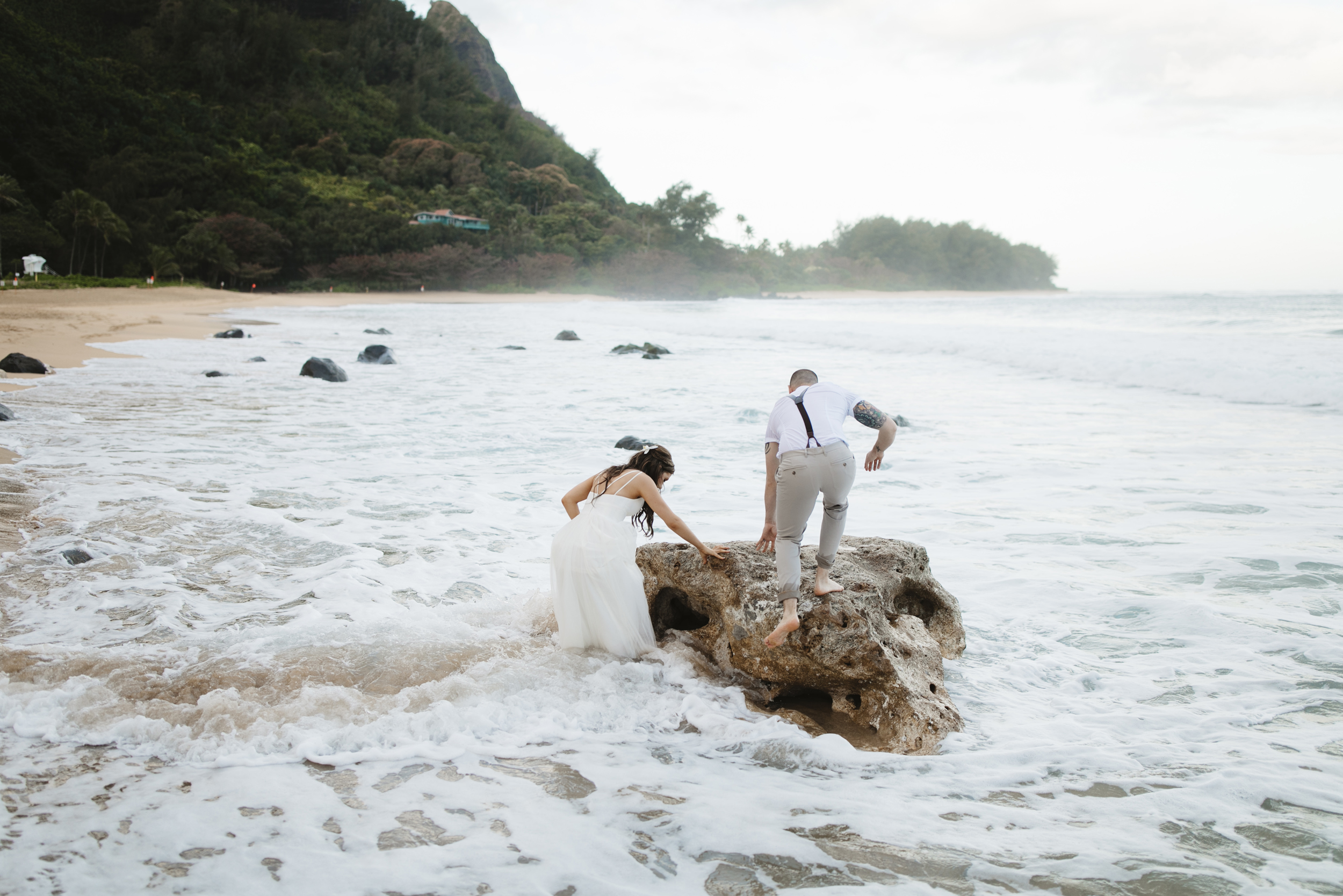 A couple playing on the beach after Tunnels Beach Elopement Ceremony by Kauai Wedding Photographers Colby and Jess