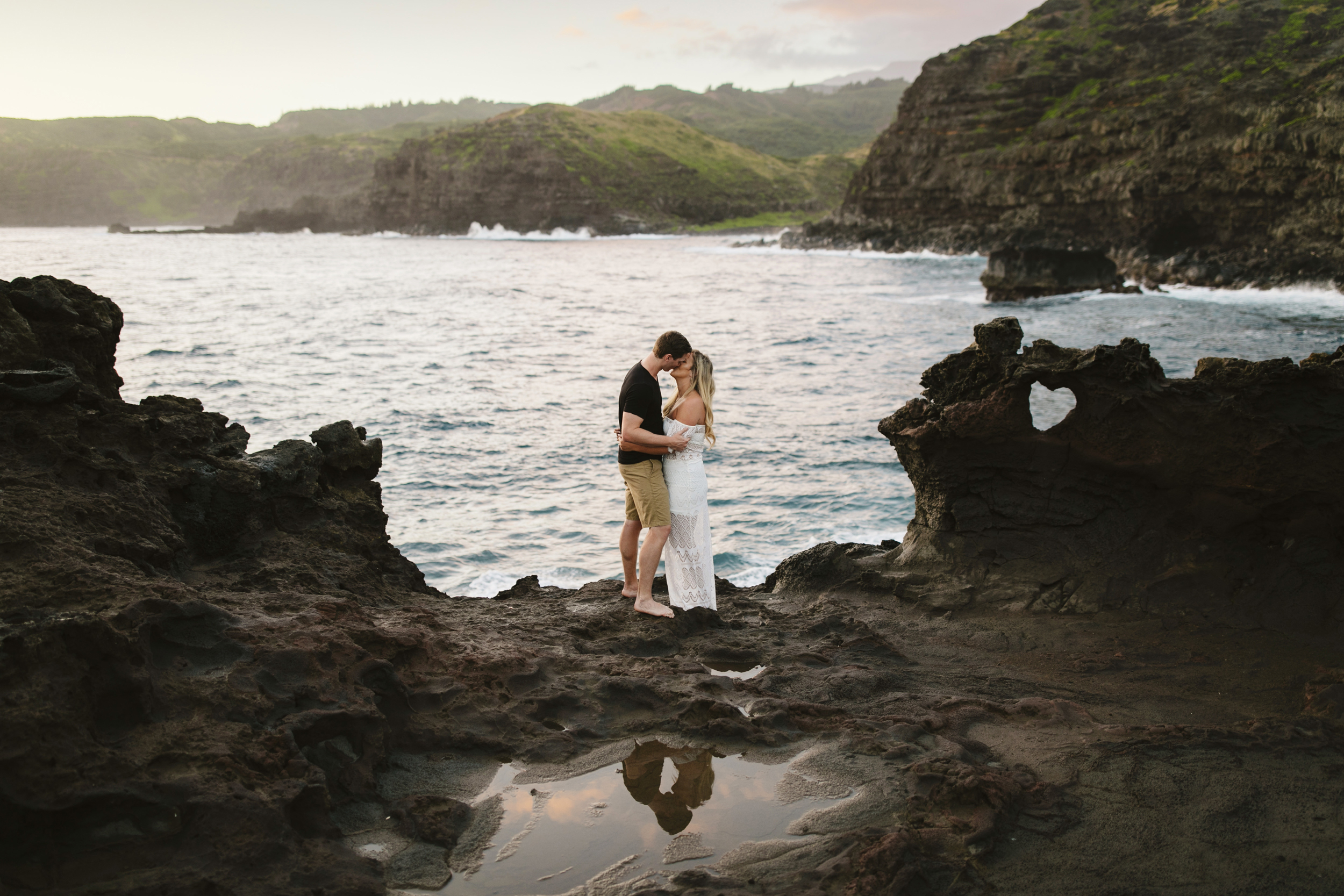 A couple kisses in Maui during their adventure engagement session by Hawaii Elopement Photographers Colby and Jess