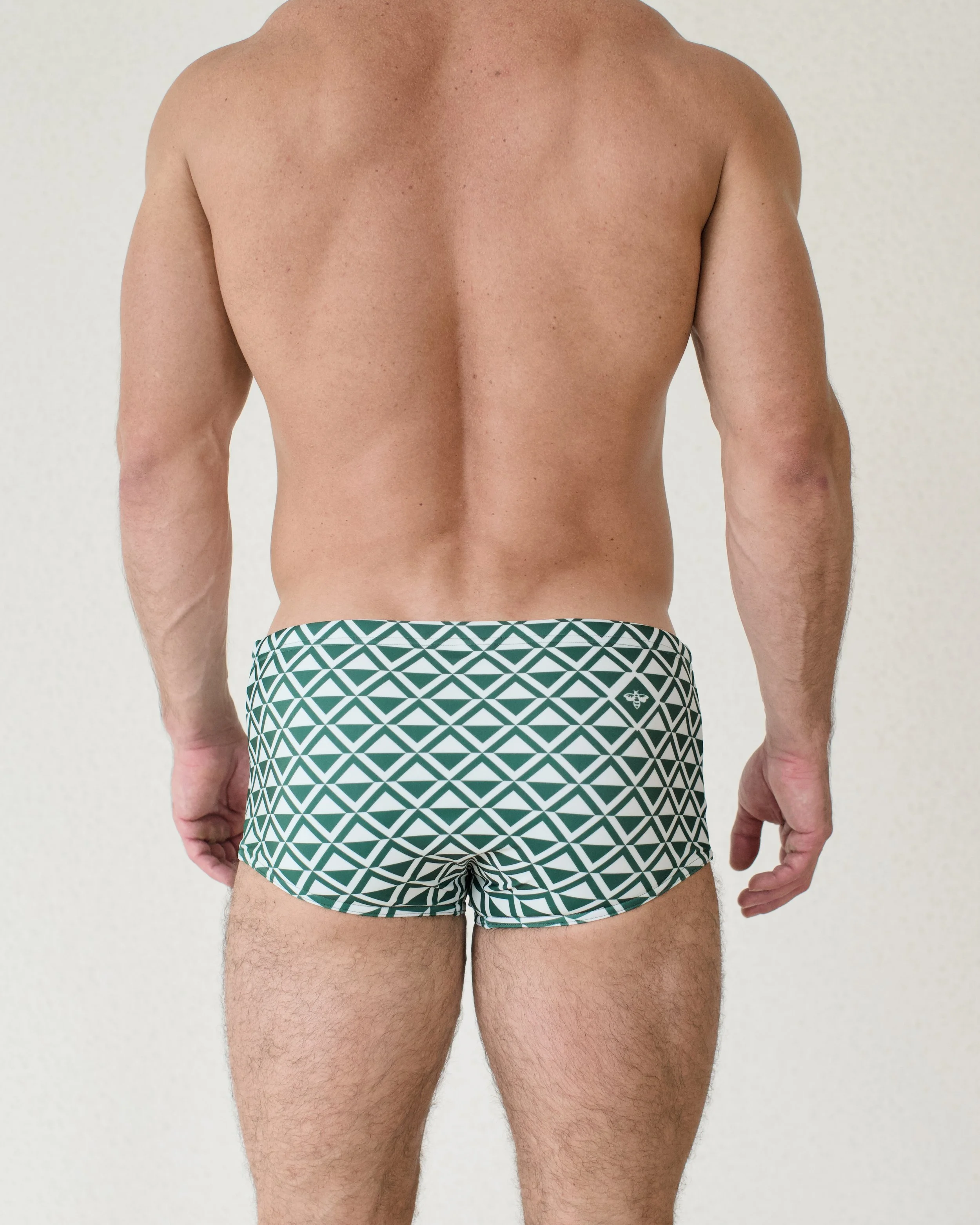 Man seen from back wearing Mint Paradigm swim sunga featuring green geometric print from Aronik Swim Paradigm Collection