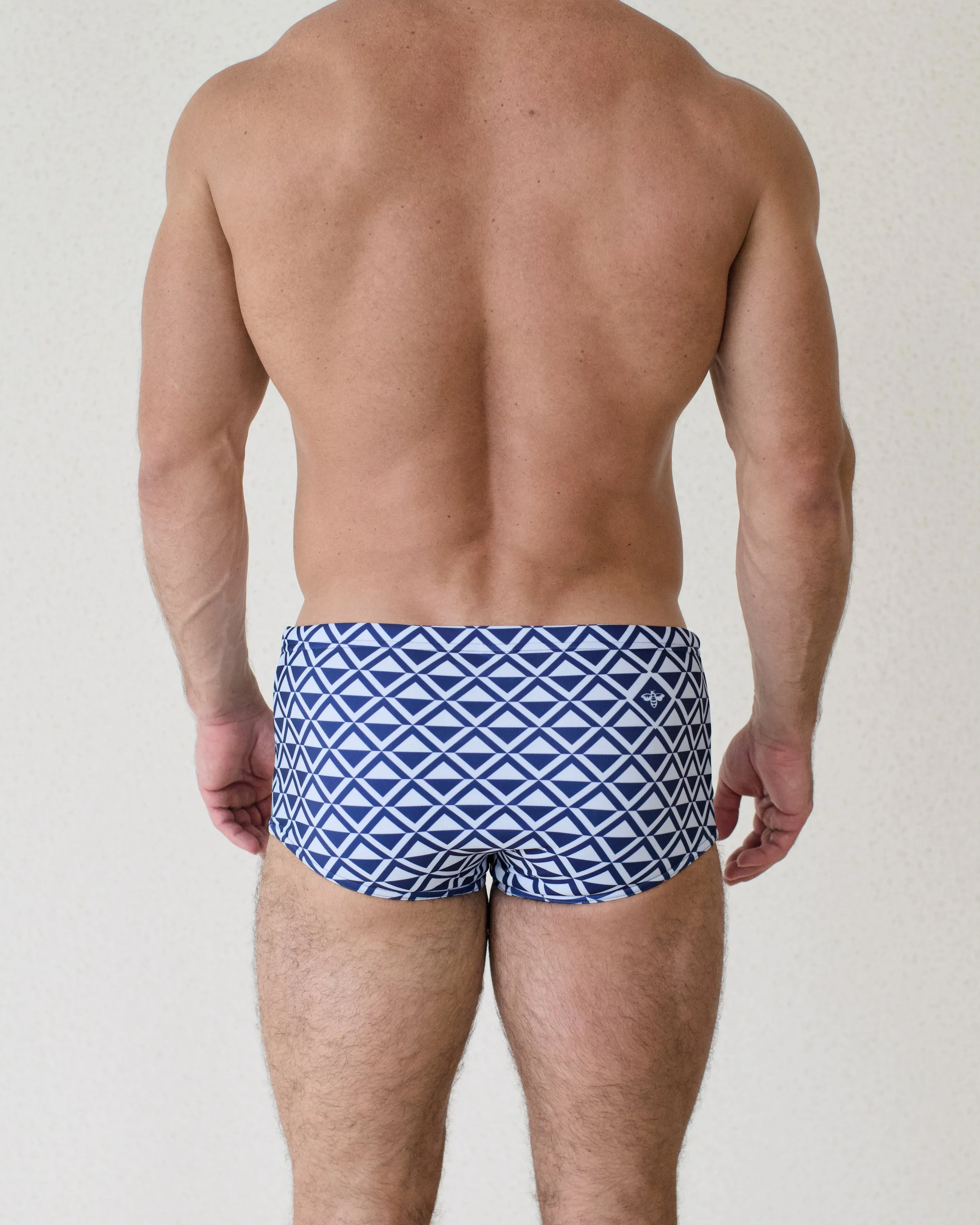 Man seen from back wearing Blu Paradigm swim sunga featuring blue geometric print from Aronik Swim Paradigm Collection