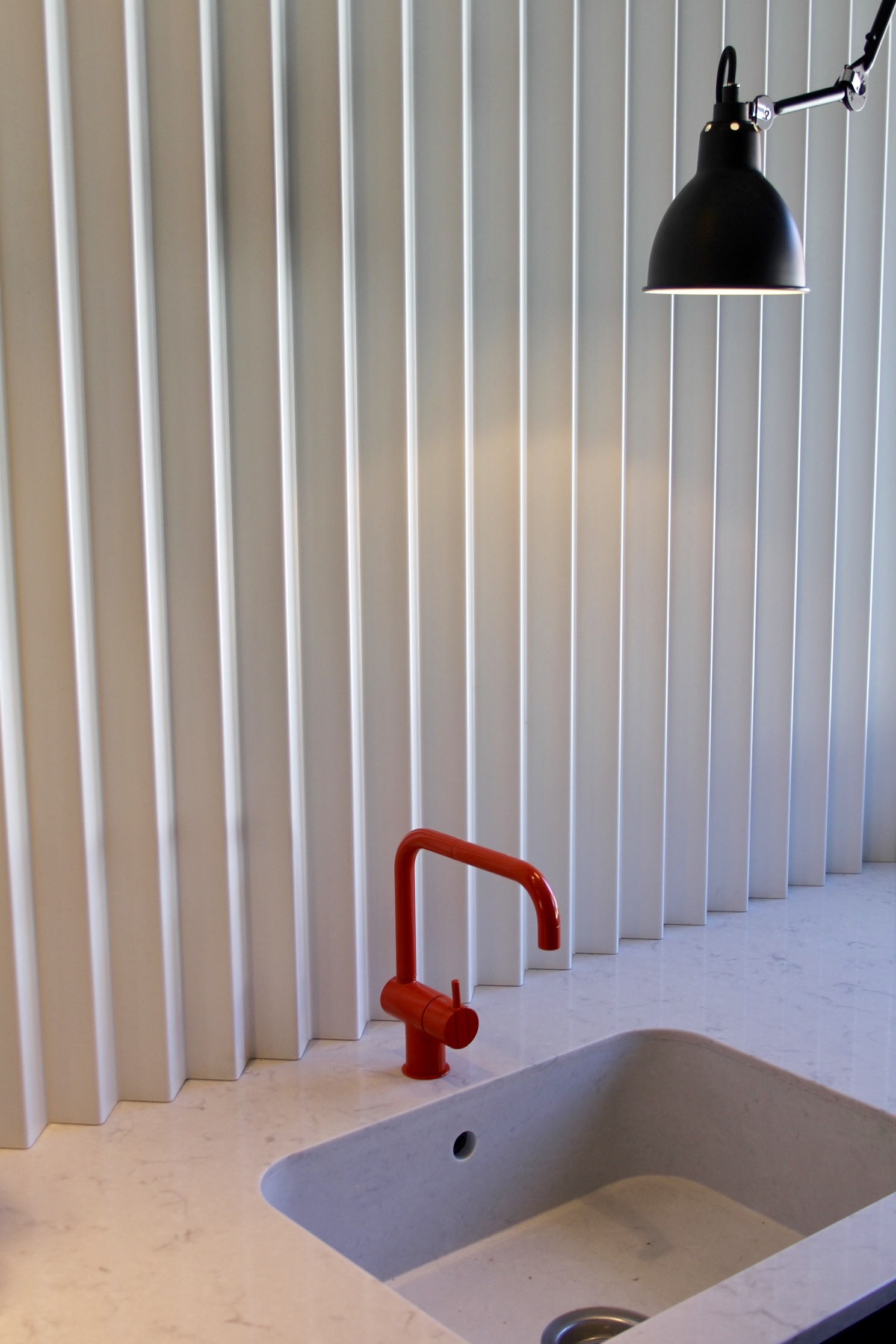  A white bespoke folded metal panel was created as a sink splash back. 