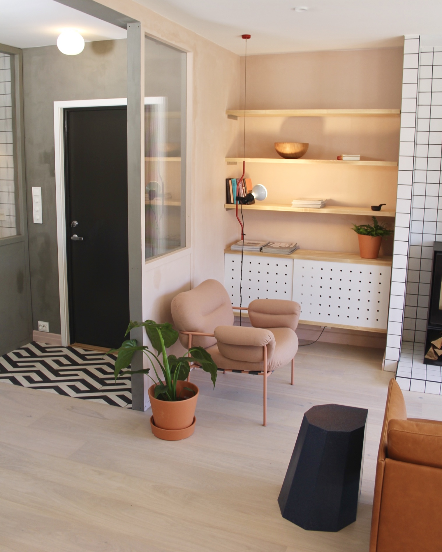  The entrance and corner of the living room has been divided by a window of fluted glass, allowing light to pass through. 