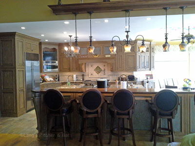 Kitchen design in New Hope, PA with distressed grey cabinets and island offset by a stylish lighting design.