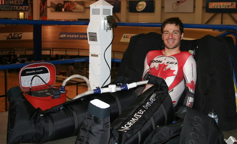 Zach Bell spends some time in his Normatec boots in between track sessions.