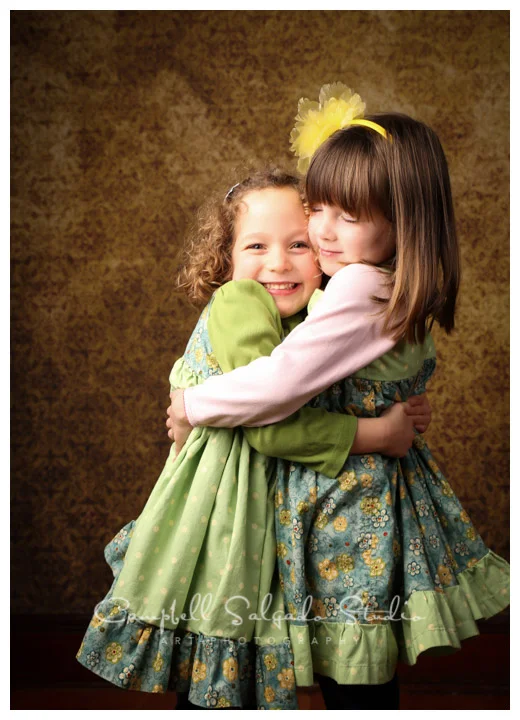 Portrait of twin girls on vintage yellow background at Campbell Salgado Studio.