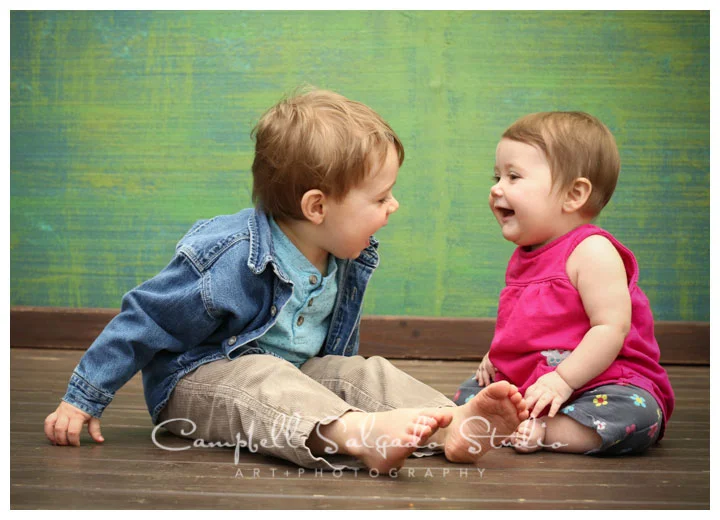 Portrait of siblings on green weave background at child photographers at Campbell Salgado Studio.