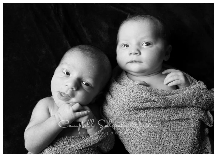 B&W portrait of twins on black background at Campbell Salgado Studio.