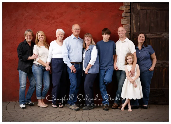 Portrait of extended family on red stucco background at Campbell Salgado Studio.