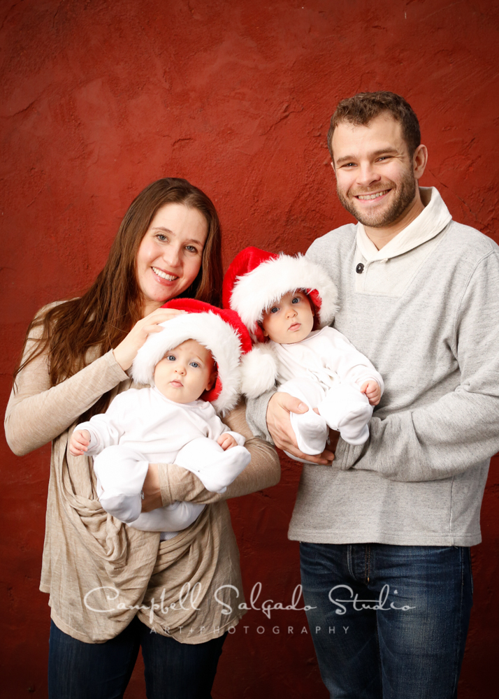  Holiday portrait of family on red stucco background&nbsp;by family photographers at Campbell Salgado Studio, Portland, Oregon. 