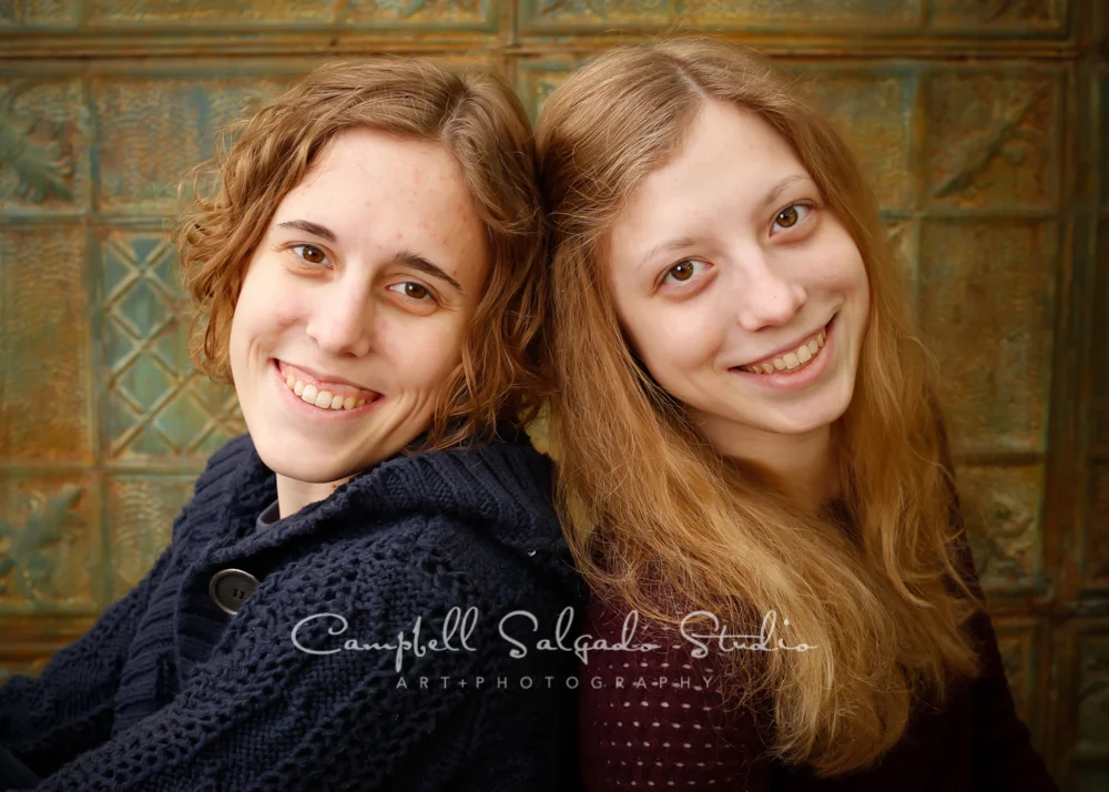Portrait of sisters on vintage colored tin background by family photographers at Campbell Salgado Studio, Portland, Oregon.