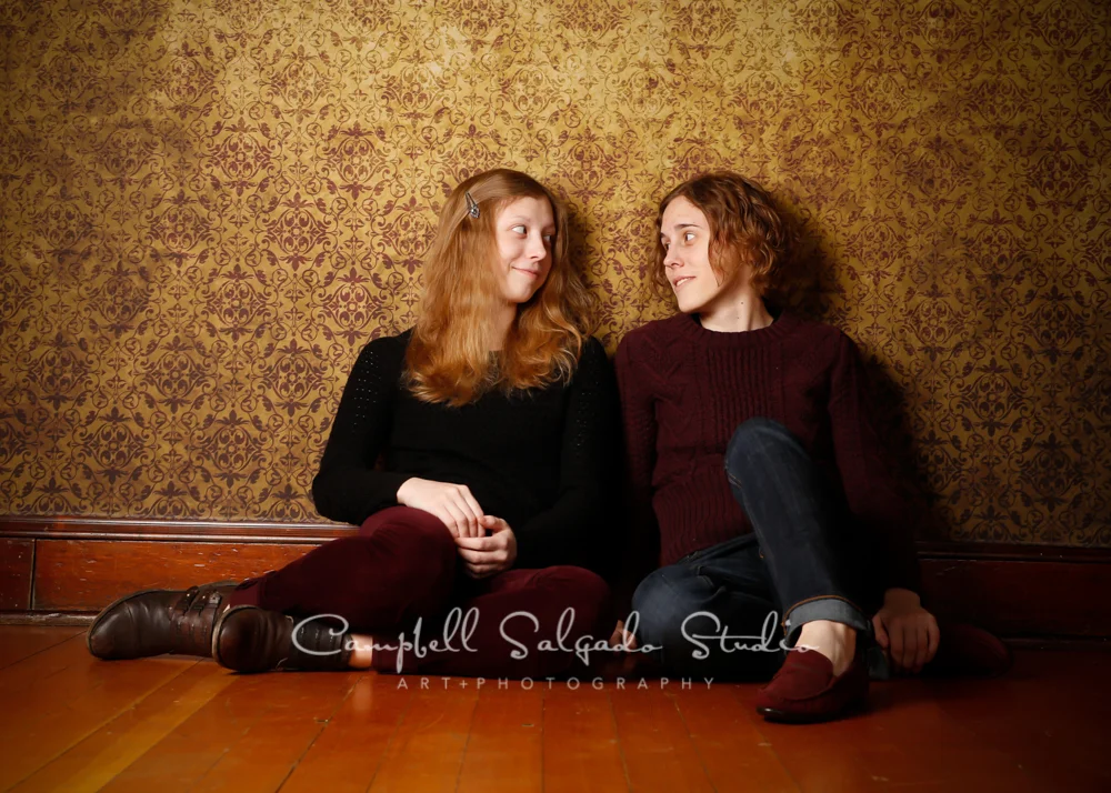 Portrait of sisters on amber light background by family photographers at Campbell Salgado Studio, Portland, Oregon.