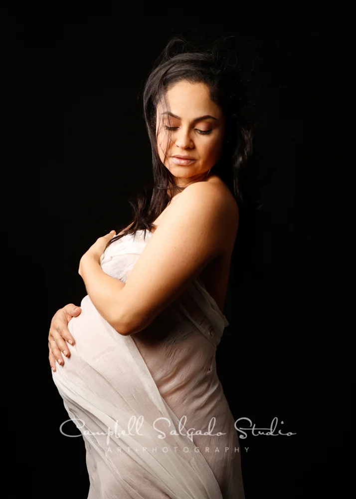 Maternity portrait of woman on black background by maternity photographers at Campbell Salgado Studio, Portland, Oregon.