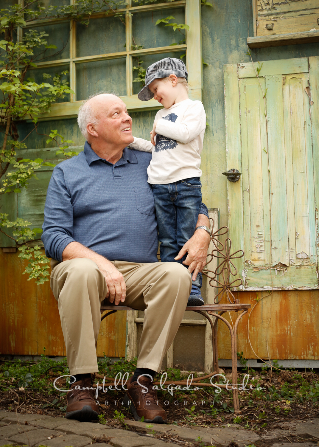  Portrait of child and grandfather on vintage green doors background&nbsp;by childrens photographers at Campbell Salgado Studio, Portland, Oregon. 