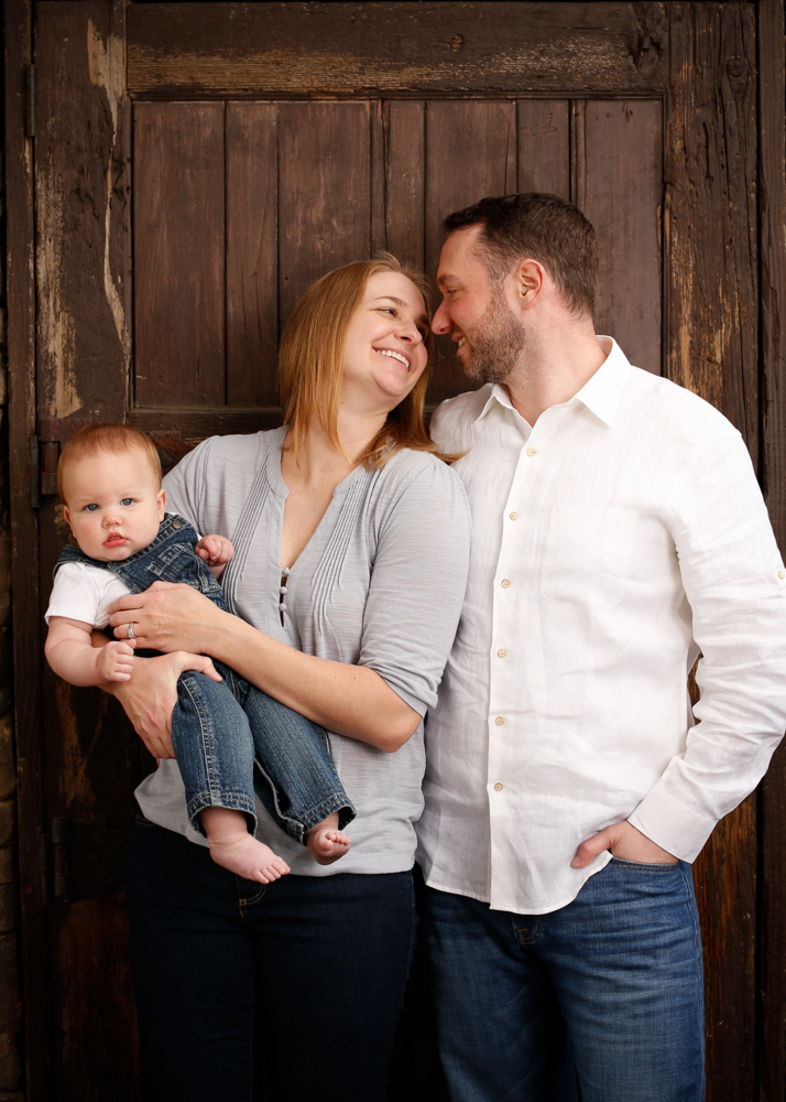  Portrait of family on rustic door background&nbsp;by family photographers at Campbell Salgado Studio, Portland, Oregon. 