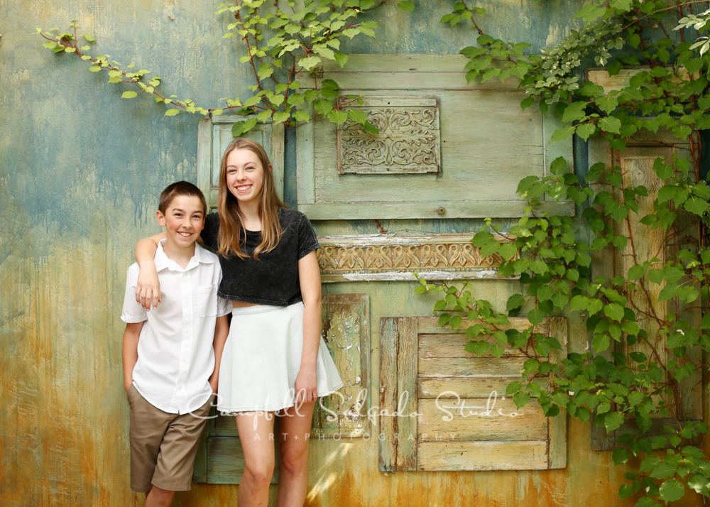  Portrait of kids&nbsp;on vintage green doors background&nbsp;by family photographers at Campbell Salgado Studio, Portland, Oregon. 