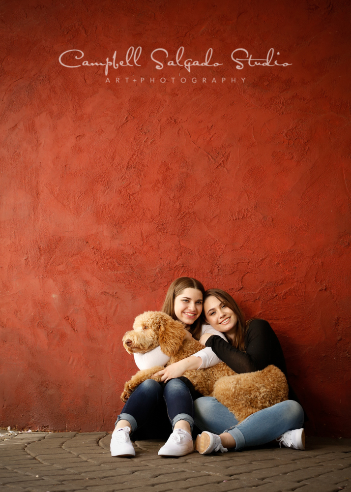  Portrait of sisters&nbsp;on red stucco background&nbsp;by child&nbsp;&nbsp;photographers at Campbell Salgado Studio, Portland, Oregon. 