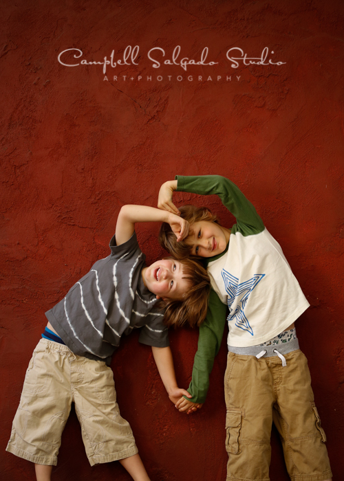  Portrait of boys&nbsp;on red stucco&nbsp;background&nbsp;by kids&nbsp;photographers at Campbell Salgado Studio, Portland, Oregon. 