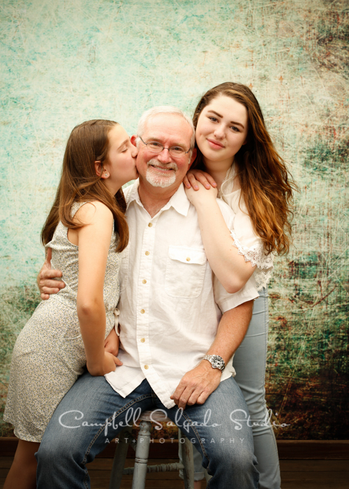  Portrait of father&nbsp;and daughters on weathered green background&nbsp;by family photographers at Campbell Salgado Studio, Portland, Oregon. 