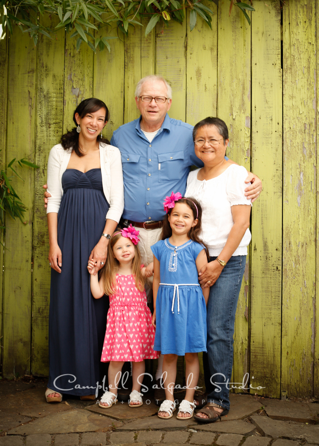  Portrait of multi-generational family on lime fence boards background&nbsp;by family photographers at Campbell Salgado Studio, Portland, Oregon. 