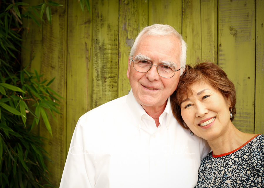  Portrait of couple on lime fence boards background&nbsp;by couple's&nbsp;photographers at Campbell Salgado Studio, Portland, Oregon. 