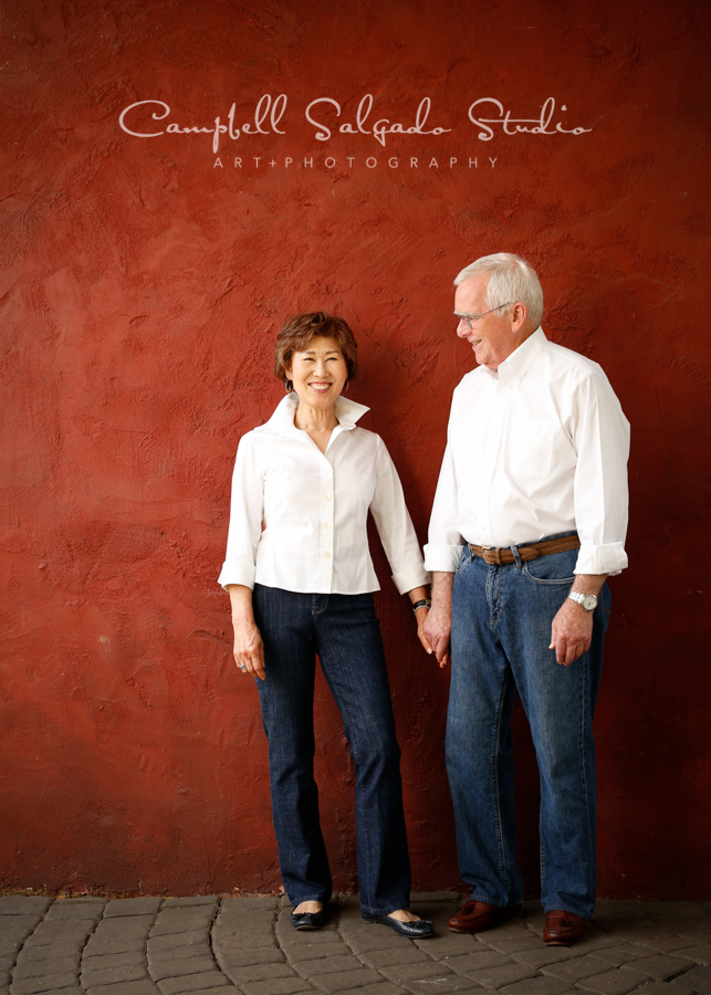  Portrait of couple on red stucco background&nbsp;by couple's&nbsp;photographers at Campbell Salgado Studio, Portland, Oregon. 