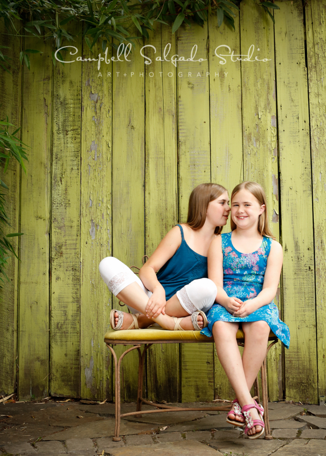  Portrait of sisters on lime fence boards background&nbsp;by family photographers at Campbell Salgado Studio, Portland, Oregon. 
