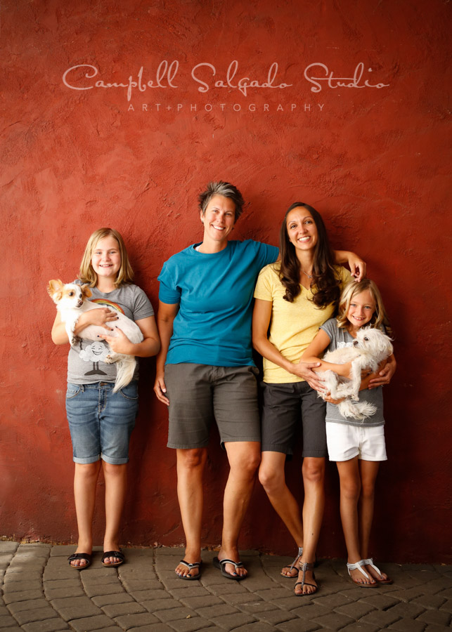  Portrait of family on red stucco background by family photographers at Campbell Salgado Studio in Portland, Oregon. 