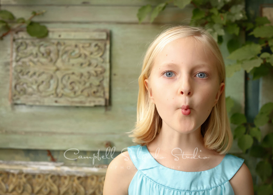  Portrait of girl on vintage green doors background by children's photographers at Campbell Salgado Studio in Portland, Oregon. 