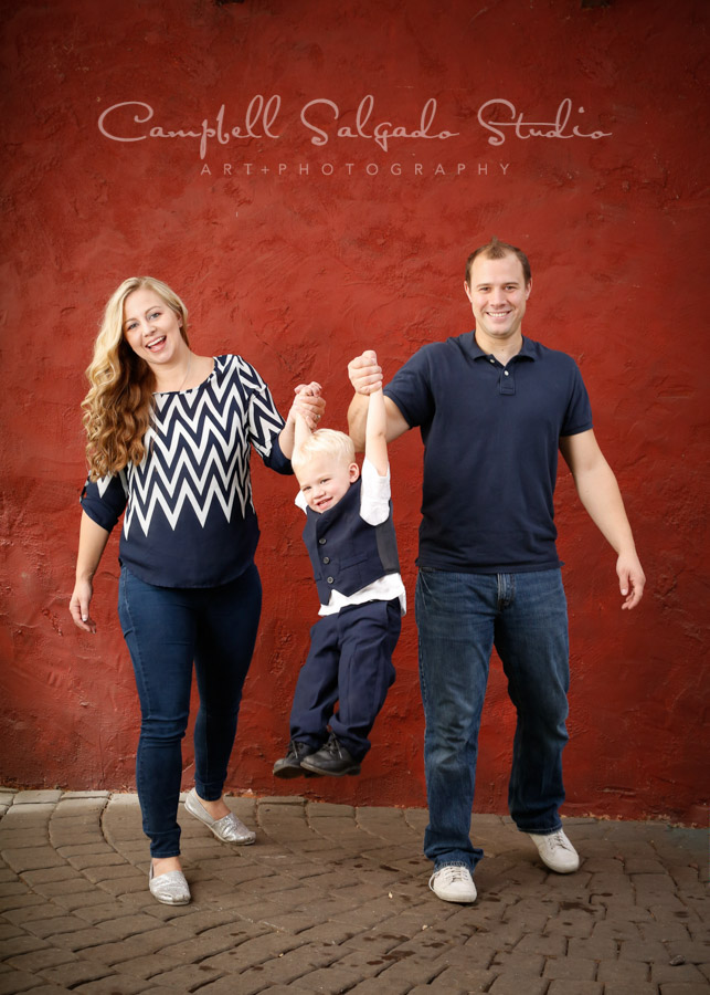  Portrait of family on red stucco background by family photographers at Campbell Salgado Studio in Portland, Oregon. 