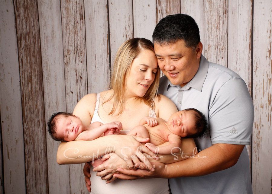  Portrait of family on white fence boards background by family photographers at Campbell Salgado Studio in Portland, Oregon. 