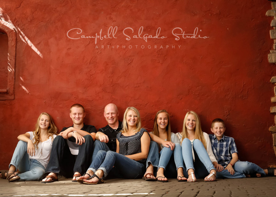  Portrait of family on red stucco background by family photographers at Campbell Salgado Studio in Portland, Oregon. 