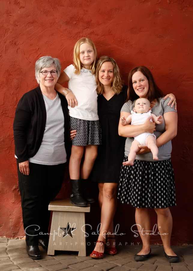  Portrait of multi-generational family on red stucco background by family photographers at Campbell Salgado Studio in Portland, Oregon. 