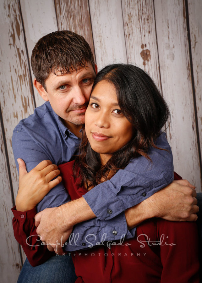  Portrait of couple on white fenceboards background by family photographers at Campbell Salgado Studio in Portland, Oregon. 